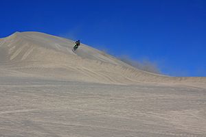 A471, Christmas Valley Sand Dunes, Oregon, USA, motorcyclist climbs a dune, 2016