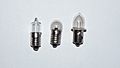 Three miniature bulbs: tubular bulb with screw base, globular bulb with screw base, and prefocus bulb with flange-mount base