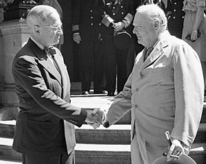 President Harry Truman and Winston Churchill shake hands on the steps of Truman's residence during the Potsdam conference, 16 July 1945. BU8944 (cropped)