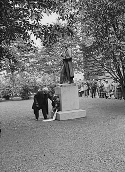 Aarne Pietinen - Photograph of sculptor Ville Vallgren setting a wreath by his statue of Albert Edelfelt