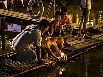 Thai people setting their candle-lit krathongs in the Ping river at night during Loy Krathong 2015-10 (22715933524).jpg