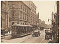 (Looking north along George Street (with tram, T-model Ford and hansom cab) from Union Line Building (incorporating the Bjelke-Petersen School of Physical culture), corner Jamieson Street), n.d. by (5955844045)