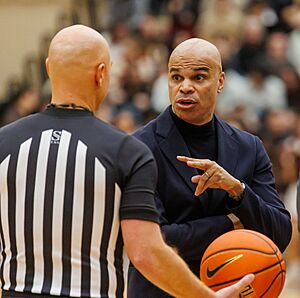 Harvard coach Tommy Amaker has a chat with the referee