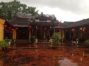 Viro lavas trotuaron sub pluvo en Hoi An 01