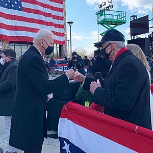 Joe Biden and Tom Carper fist bumping at Biden's farewell address in Delaware