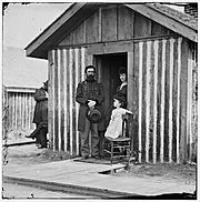 City Point, Va. Brig. Gen. John A. Rawlins, Chief of Staff, with wife and child at door of their quarters