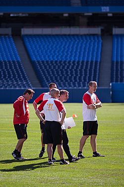 The coaching team of the Liverpool Football Club monitoring players during a training session.