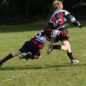 Schoolkids doing a rugby tackle