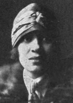 A young African-American woman wearing a cloche hat low over her ears and brow.