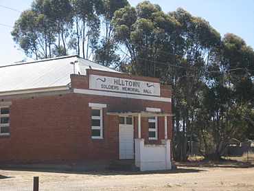 a red brick building with gum trees behind