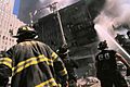 Three New York City fire fighters in front of burning building following September 11th terrorist attack (29318406842)