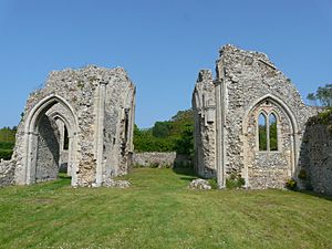 The ruin of the abbey, made of flint. The sides the nave aisles with arches survive and some window detailing, but no roof.