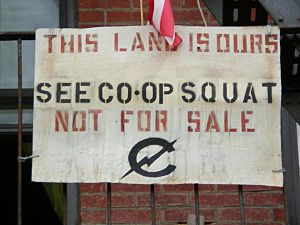 Sign that says "THIS LAND IS OURS. SEE CO-OP SQUAT. NOT FOR SALE."
