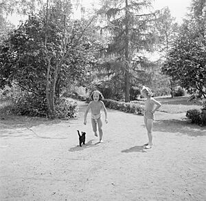 Prinses Irene met een klasgenote en een kat in de tuin, Bestanddeelnr 255-7387