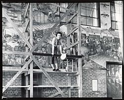 Aline H. Rhonie, American painter, 1909-1963, at work on aviation mural at Roosevelt Field, Garden City, New York