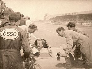 Colin Chapman in Lotus J Crosthwaite leaning on car (right)