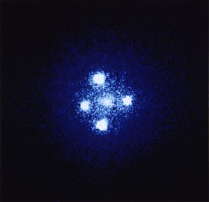 Einstein cross: Four images of the same distant quasar (due to the gravitational lensing of the galaxy closest to us, shown in the foreground, the Huchra Lens).