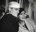 Cagney in a sailor suit with a smiling actress leaning on him.