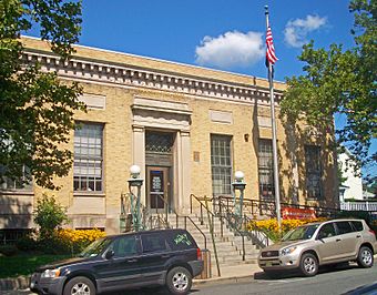 Front view of Nyack post office, with two cars parked in front