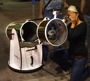 Newtonian telescope with woman looking through it