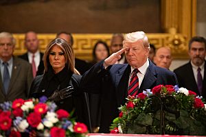 President Donald Trump salutes at the casket of former President George H. W. Bush