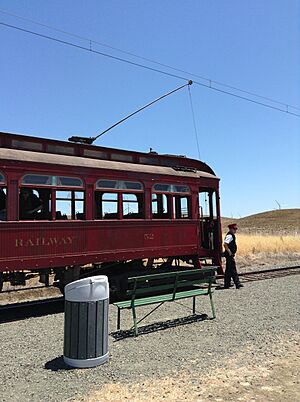 A conductor stands in front of a train from the Western Railroad Museum in Solano County