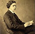 Photographic portrait of Charles Lutwidge Dodgson (Lewis Carroll), seated and holding a book