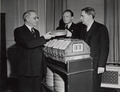 Photograph of First Archivist of the United States R. D. W. Connor Receiving Film "Gone With The Wind" from Senator George of Georgia and Loew's Eastern Division Manager Carter Barron, 1941