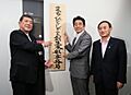 Prime Minister Shinzo Abe raising a signboard