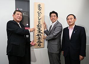 Prime Minister Shinzo Abe raising a signboard