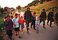 990628-M-5696S-025 - U.S. Marines march with local children down street of Zegra, Kosovo