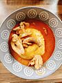 Fufu with light soup and chicken in a ceramic bowl