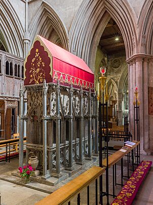 A tall rectangular monument with a canopy of embroidered red cloth  