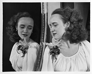 Black and white photograph of Charlotte Davis Mooers posing by a mirror.