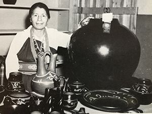 Margaret Tafoya in 1956 with large blackware pot, and a black-on-black platter in foreground
