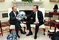 President George H. W. Bush receives a Dallas Cowboys jacket and helmet from Jerry Jones