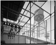 VIEW OF WATER TOWER FROM ELECTRICAL TRANSFORMER CAGE AT NORTH END OF SECOND FLOOR WAREHOUSE. VIEW TO WEST-NORTHWEST. - Ford Motor Company Long Beach Assembly Plant, Assembly HAER CAL,19-LONGB,2-A-4