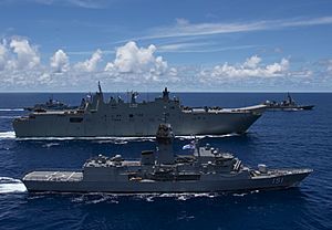 HMAS Arunta and Canberra sailing in formation with other warships