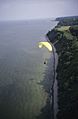 Paraglider soaring over coast