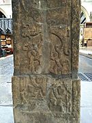 Leeds Cross panel Ciii, depicting Weland/Vǫlundr (below, strapped into wings, with tools at his feet) holding Beaduhild/Bǫðvildr (above, at a right angle to Weland). The bottom left quadrant is a modern reconstruction.