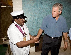 President George W. Bush shakes the hand of legendary Fats Domino, wearing a National Medal of Arts