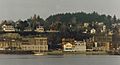 Photograph of the Port Townsend waterfront from seaside, showing several Victorian residences and commercial buildings in tiers on a hillside.