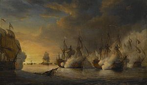 Several large 18th-century war ships under full sail and shrouded in gunsmoke