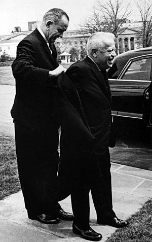 Lyndon B. Johnson helps David Dubinsky put on his coat.