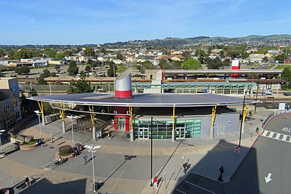 An overhead view of a semicircular metal canopy at the entrance to a large railway station