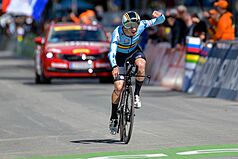Remco Evenepoel rides a time-trial bicycle, wearing a jersey which displays the flag of Belgium