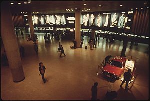 NEW CAR DISPLAY AND AMTRAK PASSENGER TRAIN TICKET COUNTERS IN THE BACKGROUND AT NEW YORK CITY'S PENNSYLVANIA STATION... - NARA - 556703
