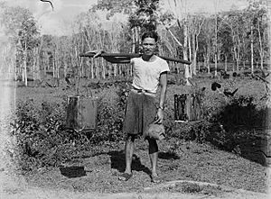 Portrait of a Samoan man carrying two containers over his shoulder (AM 86644-1)