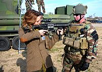 US Navy 081206-N-3346C-012 Chief Master-at-Arms Michael Minotto explains the functions of the M4 Battle Rifle to actress Hilarie Burton