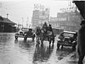 A dray, a Ford and a Morris Oxford Roadster, both 1932 models, in summer rain, Railway Square, Sydney, Jan 1935 - by Sam Hood (3293866395)